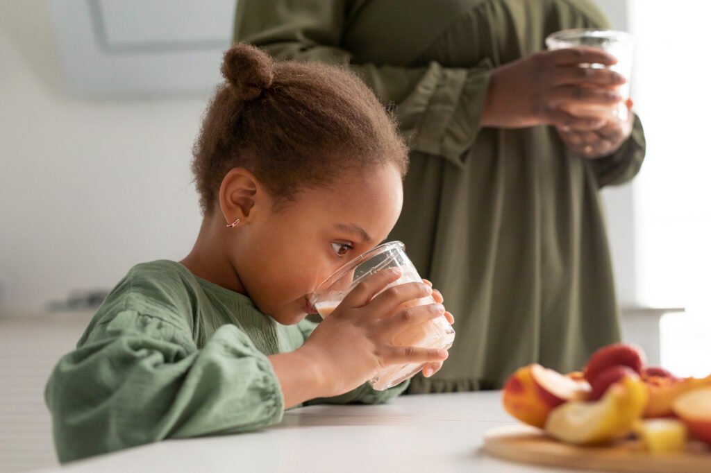 Young child drinking water to stay hydrated during hot summer weather.