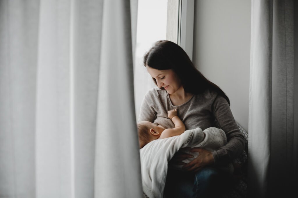 Mother feeding her newborn baby during a night feed to support healthy newborn sleep (0–3 months)