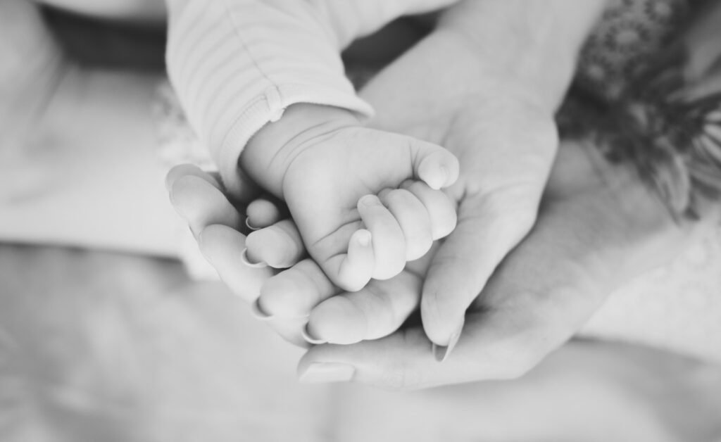Mother holding her baby's hand during a gentle sleep support journey with Bluebell Sleep Consulting.