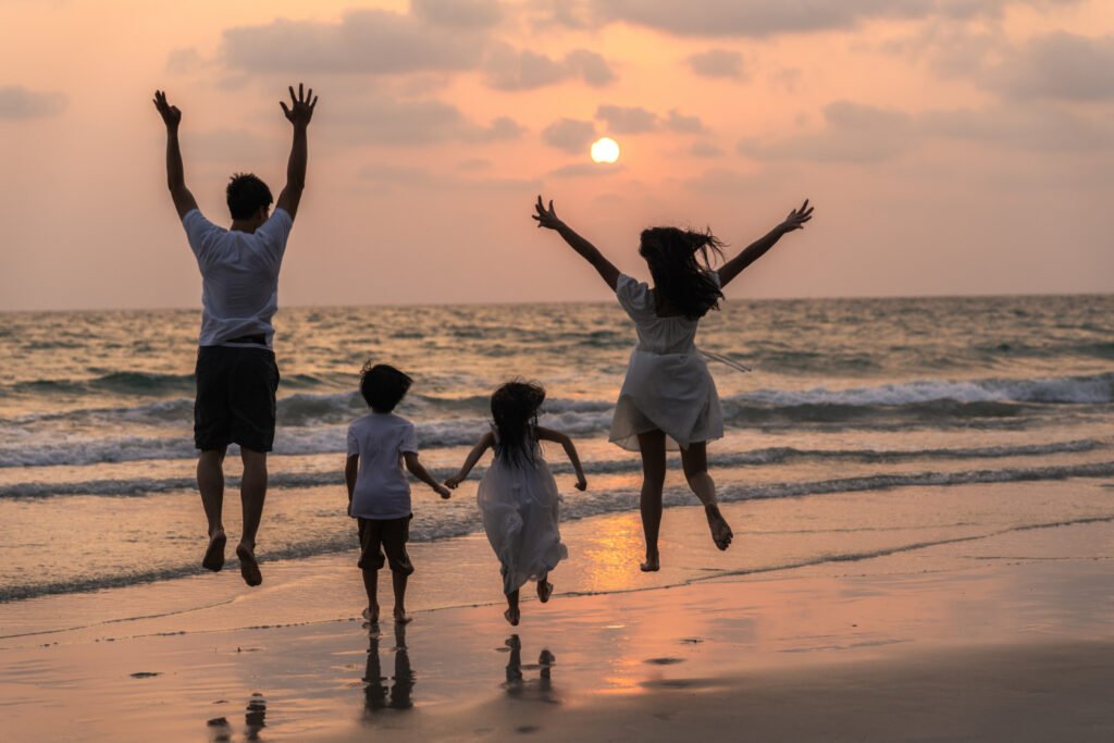 Family with children enjoying a beach holiday at sunset