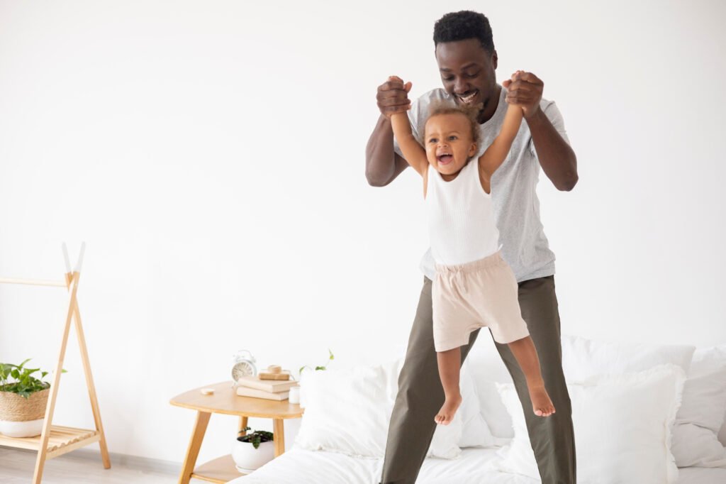 Happy toddler playing with a parent before bedtime. Active daytime play supports healthy sleep, longer nights, and better bedtime routines. Sleep regression.