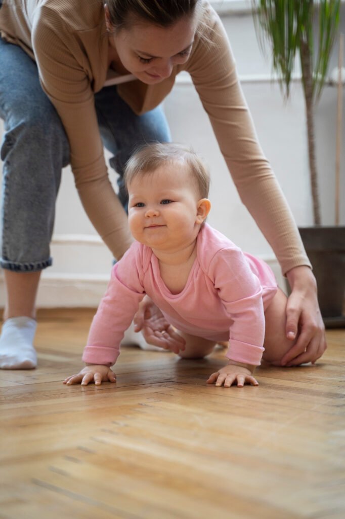 Baby learning to crawl with a parent nearby during a developmental milestone that may temporarily affect sleep and cause early morning waking.