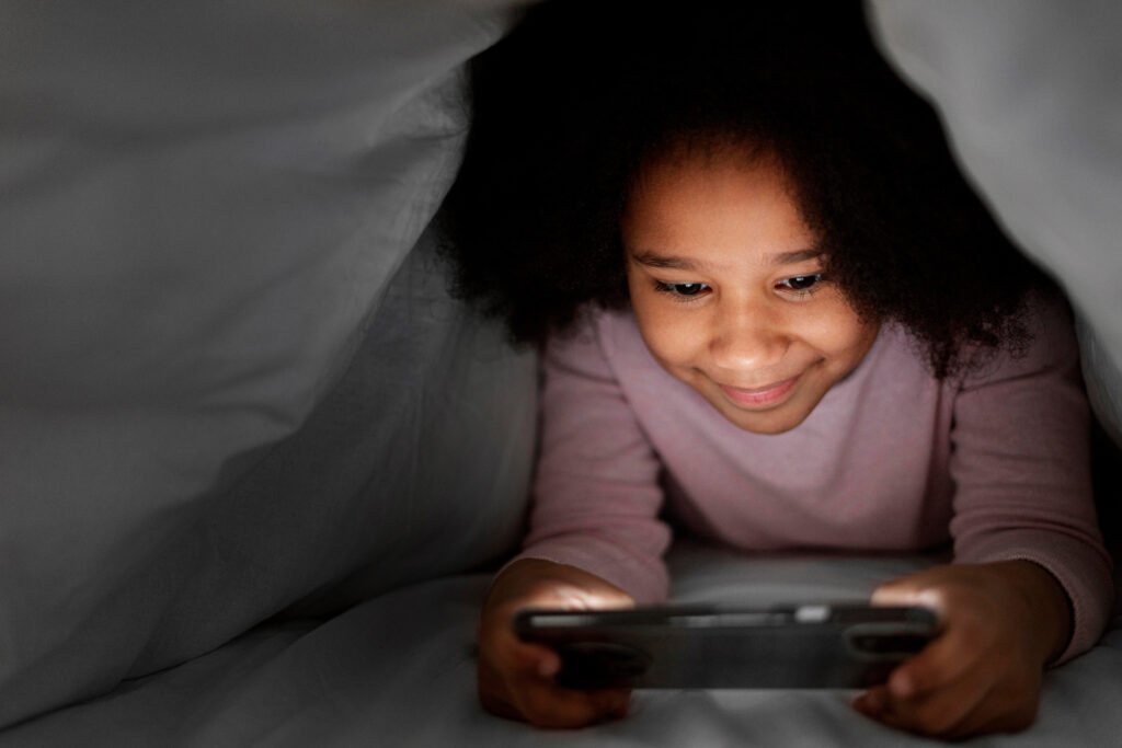 Child using a tablet at night showing how blue light may affect children's sleep