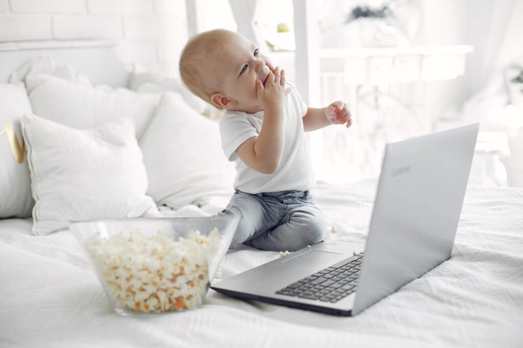Baby sitting near a laptop during screen time