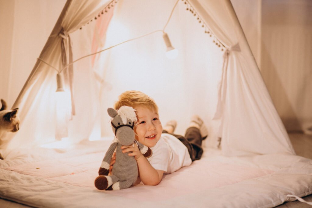 Happy toddler relaxing in bed near a sound machine