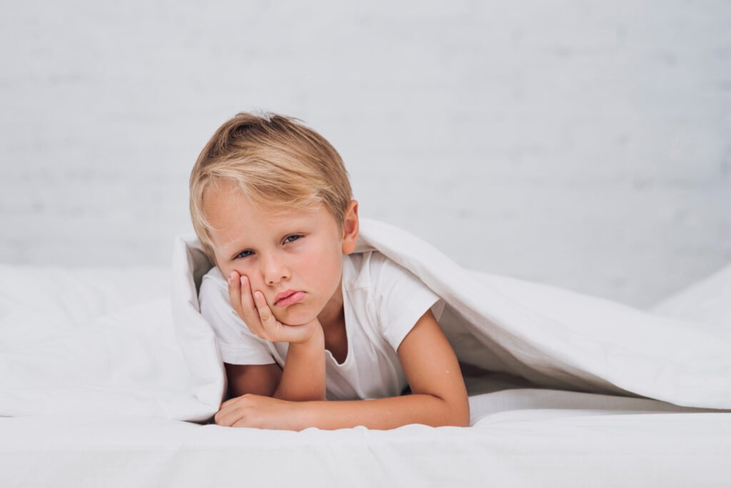 when should my child stop napping? Toddler showing signs of over tiredness, including tired eyes and low energy before bedtime or nap time.